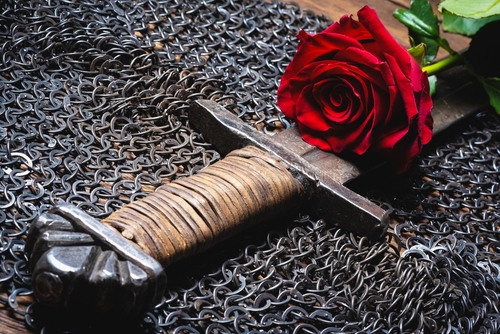 Red,Rose,Flower,And,Knight,Sword,On,The,Black,Table